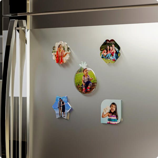 A stainless steel refrigerator door decorated with custom photo magnets showing family portraits and wedding photos