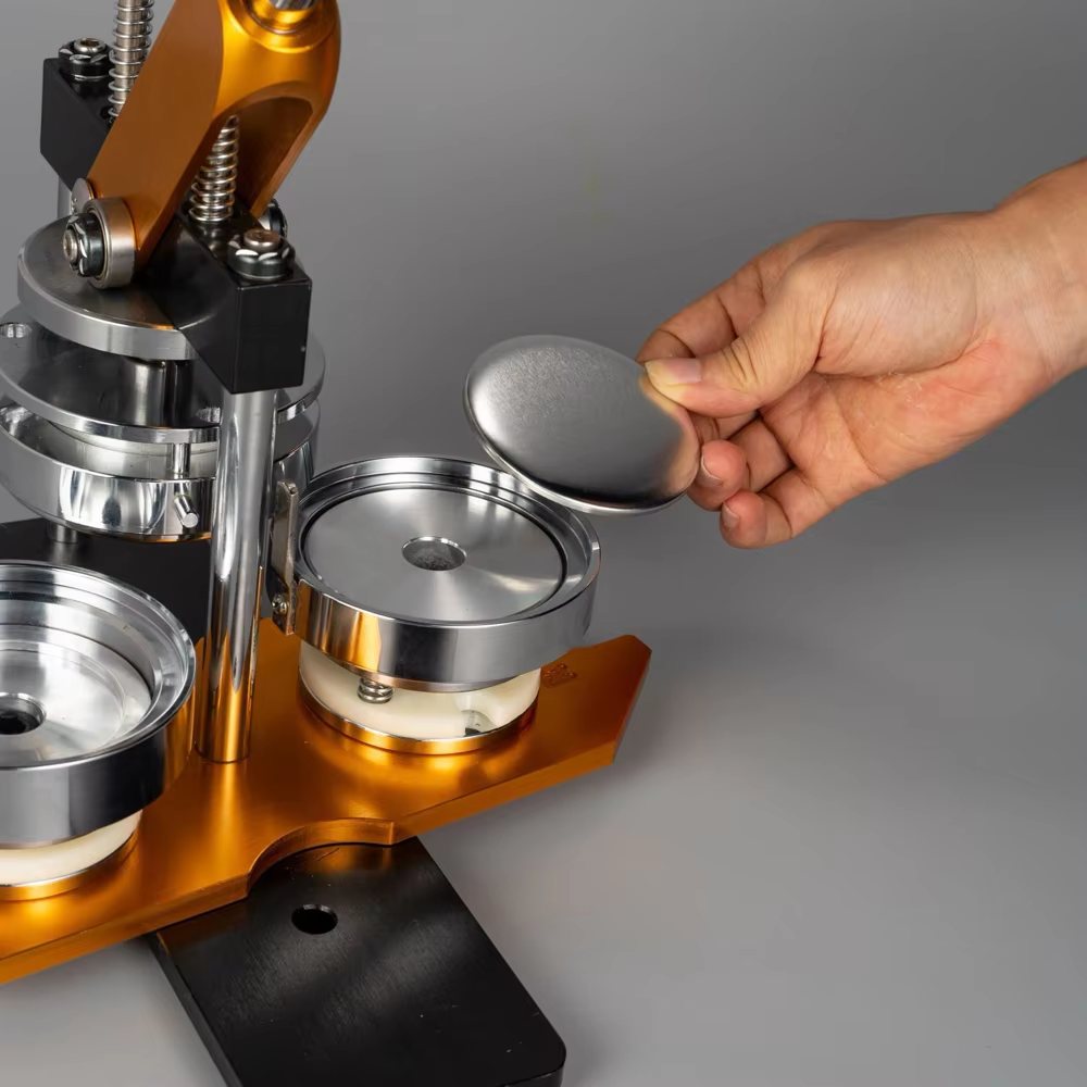 A hand placing a metal shell into the die of a magnet press to make a custom memory magnet